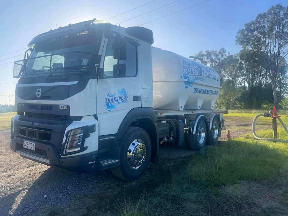 A White Truck Is Parked in A Grassy Field — Stolzenberg Water Carriers in Glenwood, QLD