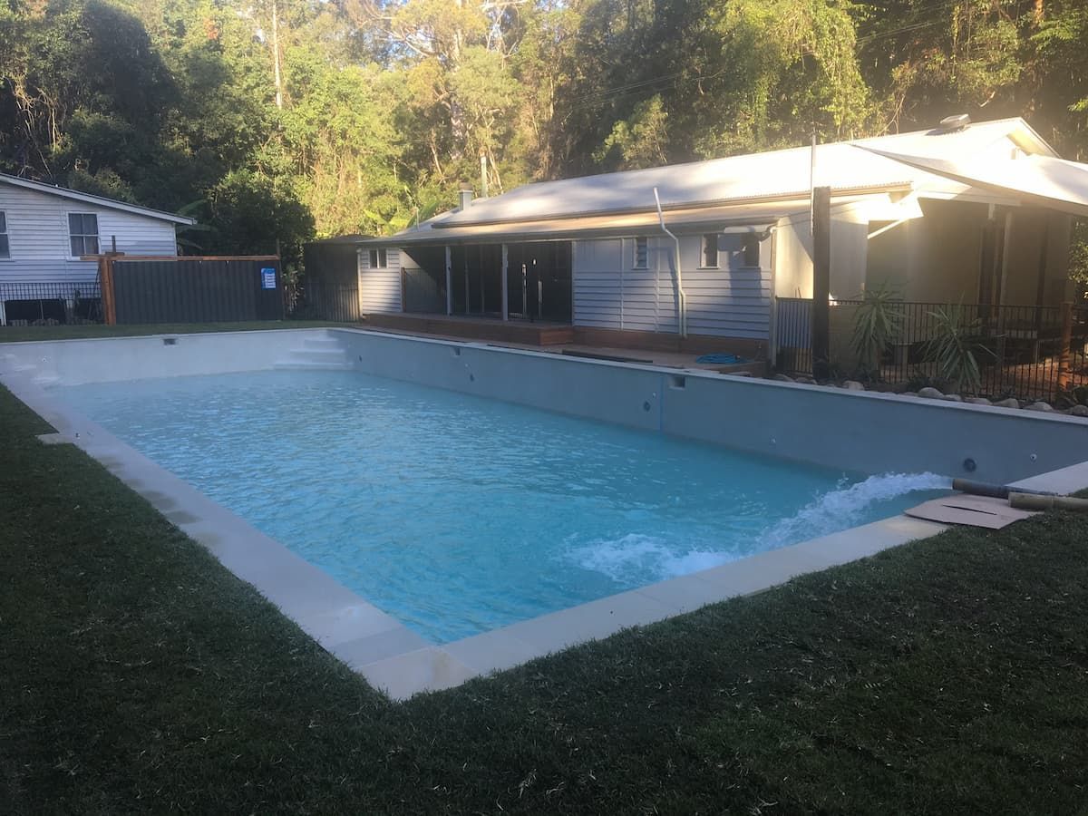 A Large Swimming Pool Is in The Backyard of A House — Stolzenberg Water Carriers in Chatsworth, QLD