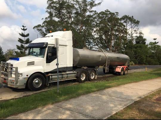 A White Semi Truck Is Parked on The Side of The Road Next to A Sidewalk — Stolzenberg Water Carriers in Chatsworth, QLD