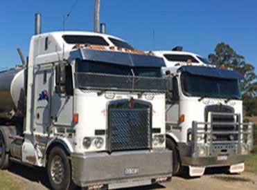 Two Semi Trucks Are Parked Next to Each Other on A Dirt Road — Stolzenberg Water Carriers in Chatsworth, QLD