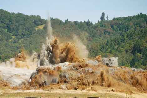 A Large Pile Of Dirt Is Being Thrown Into The Air In Front Of A Forest – Port Pirie, SA - Flinders Earthmoving & Blue Metal Supplies