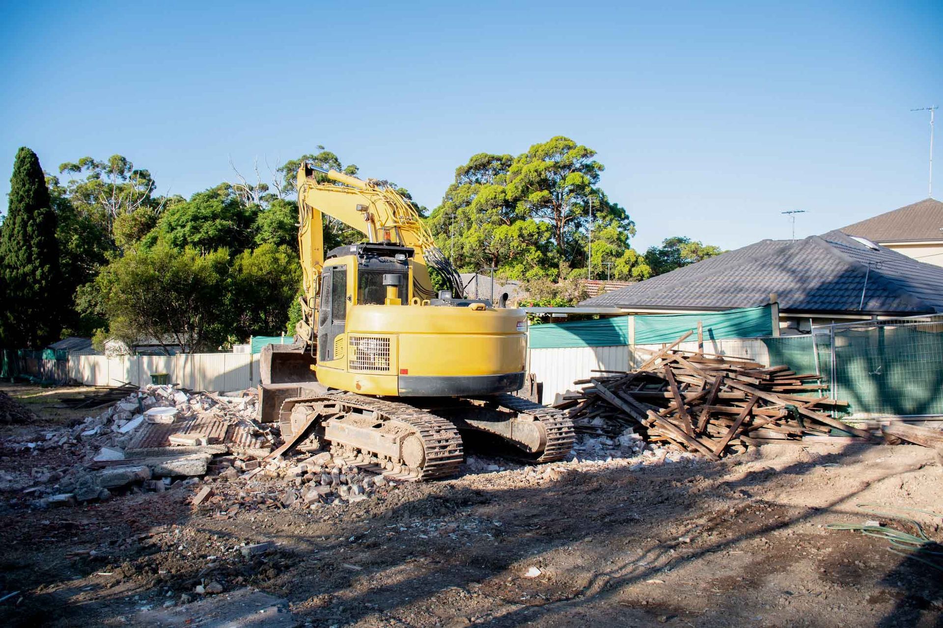 A Yellow Excavator Is Demolishing A House On A Construction Site – Port Pirie, SA - Flinders Earthmoving & Blue Metal Supplies