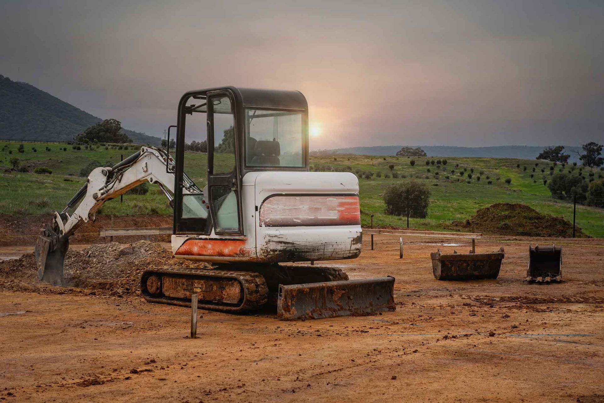 A Small Excavator Is Sitting On Top Of A Dirt Field – Port Pirie, SA - Flinders Earthmoving & Blue Metal Supplies