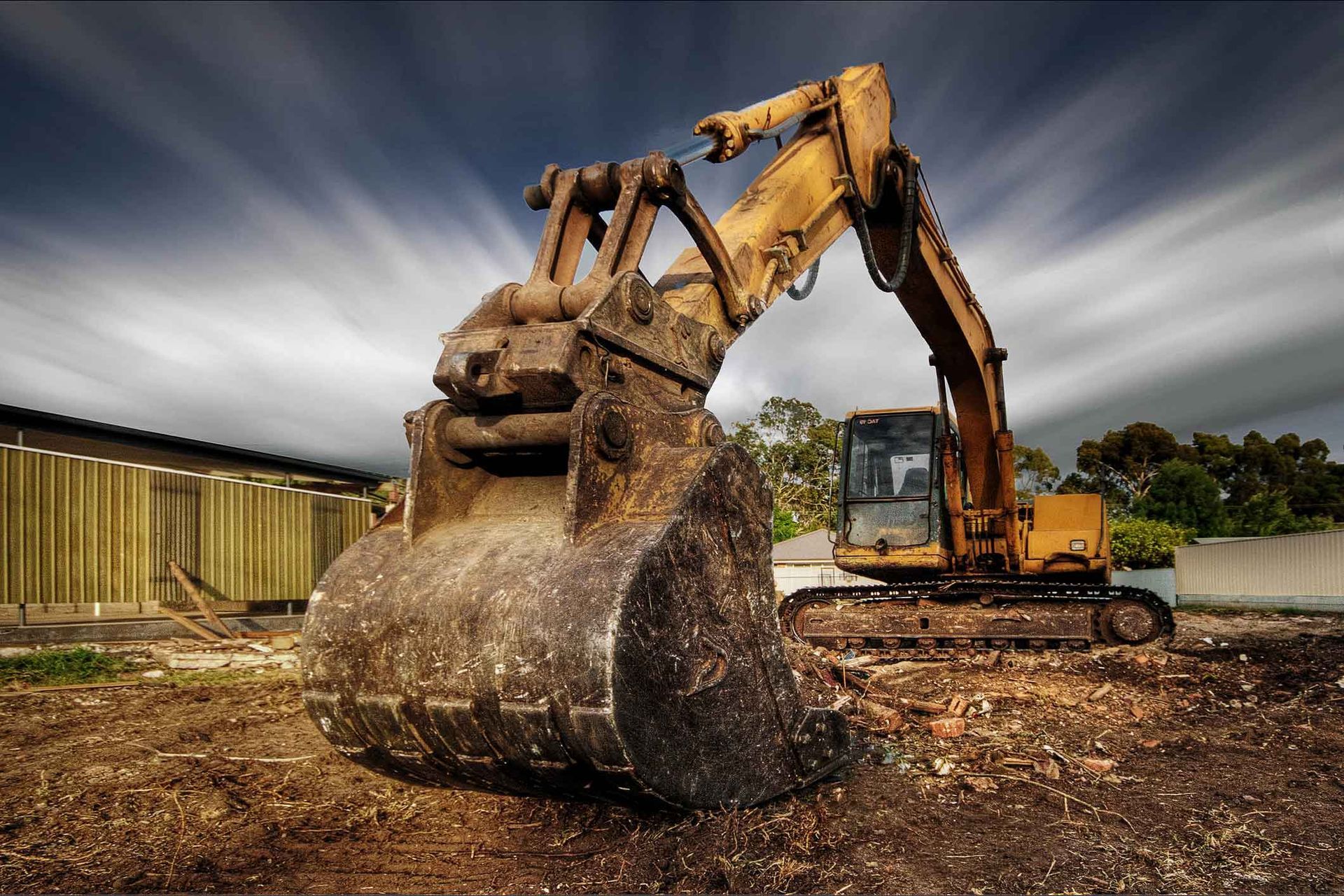A Large Yellow Excavator Is Sitting In A Dirt Field – Port Pirie, SA - Flinders Earthmoving & Blue Metal Supplies
