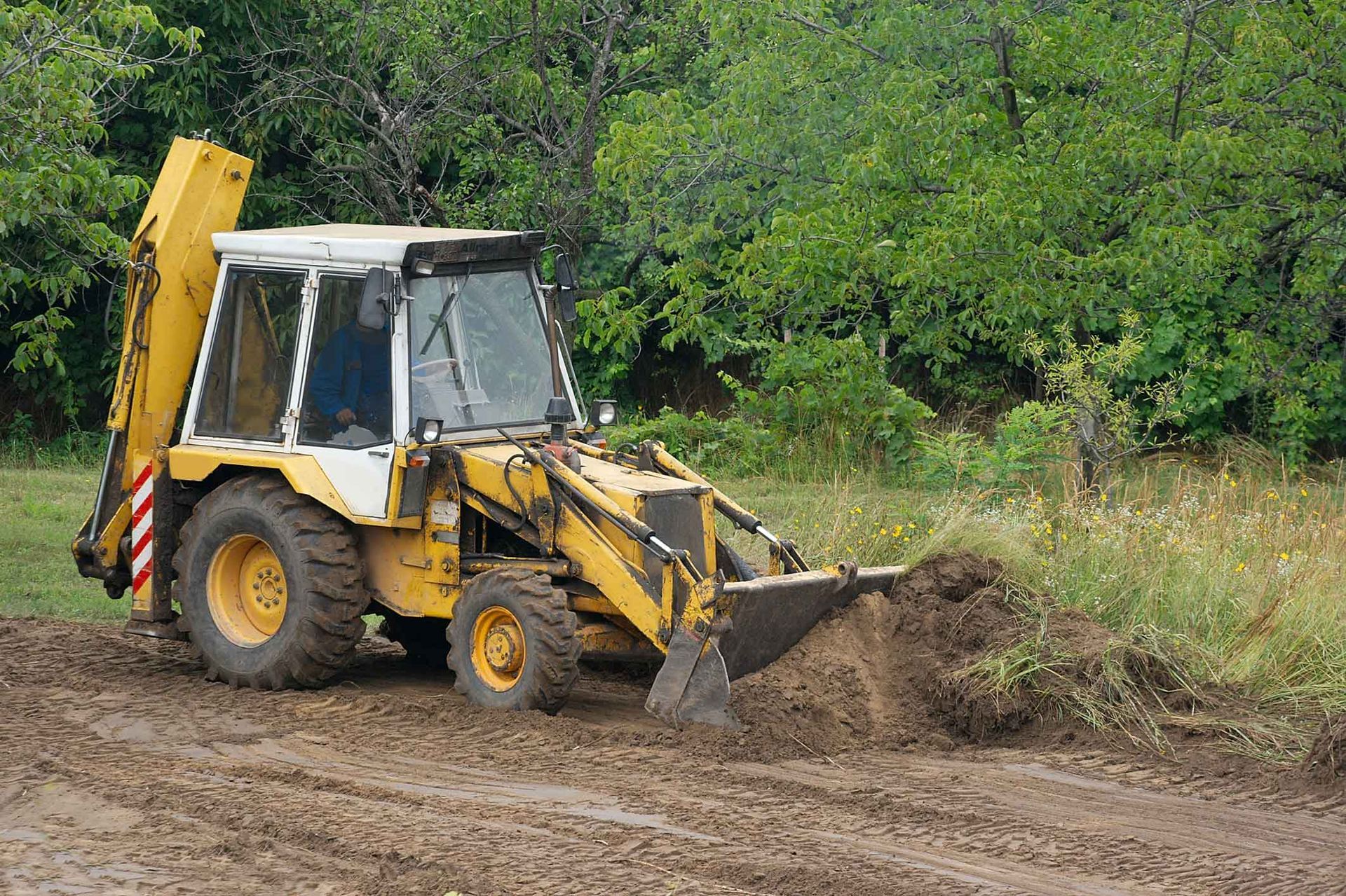 A Yellow Bulldozer Is Digging A Hole In The Dirt – Port Pirie, SA - Flinders Earthmoving & Blue Metal Supplies