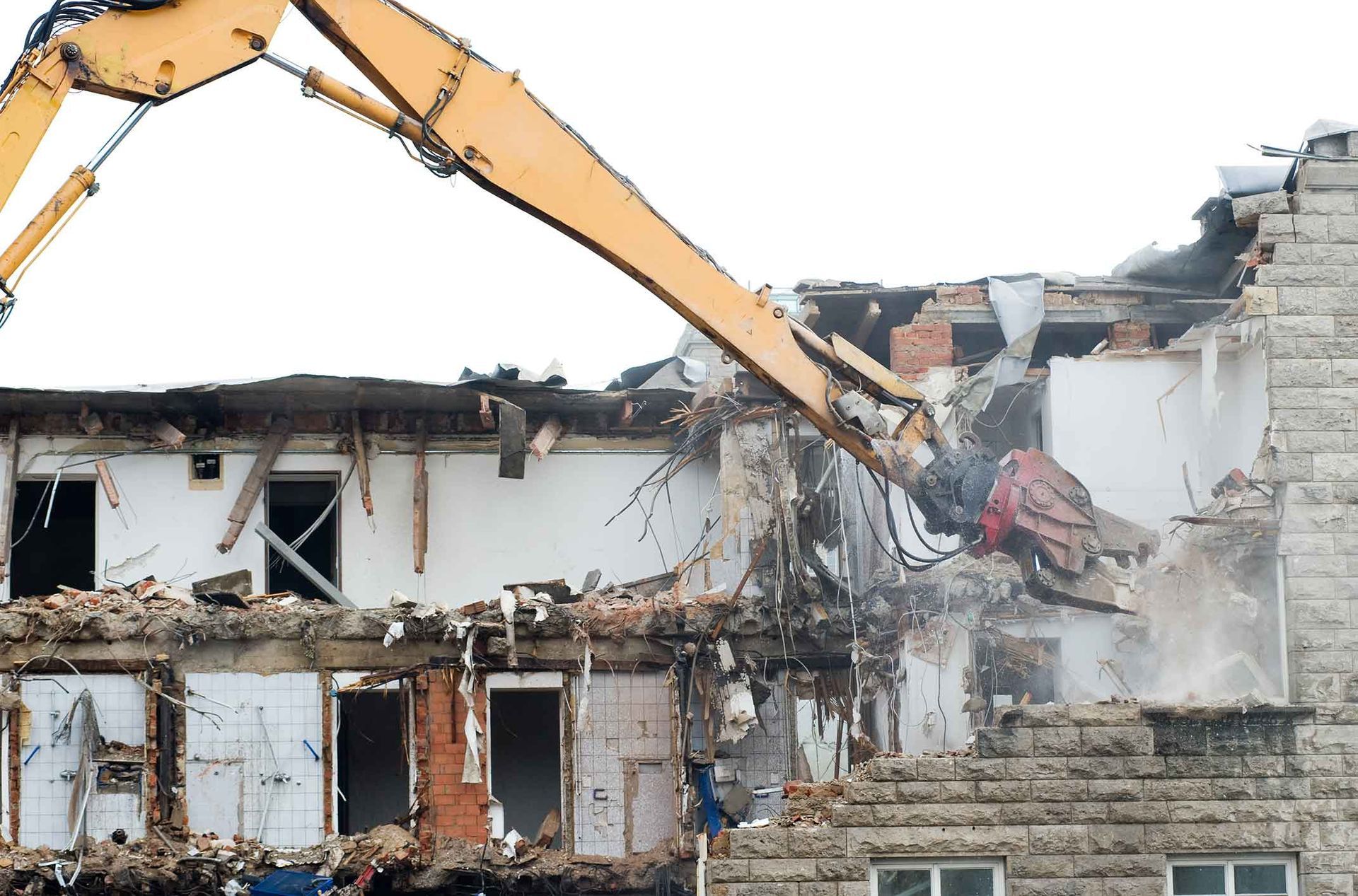 A Yellow Excavator Is Demolishing A Brick Building – Port Pirie, SA - Flinders Earthmoving & Blue Metal Supplies