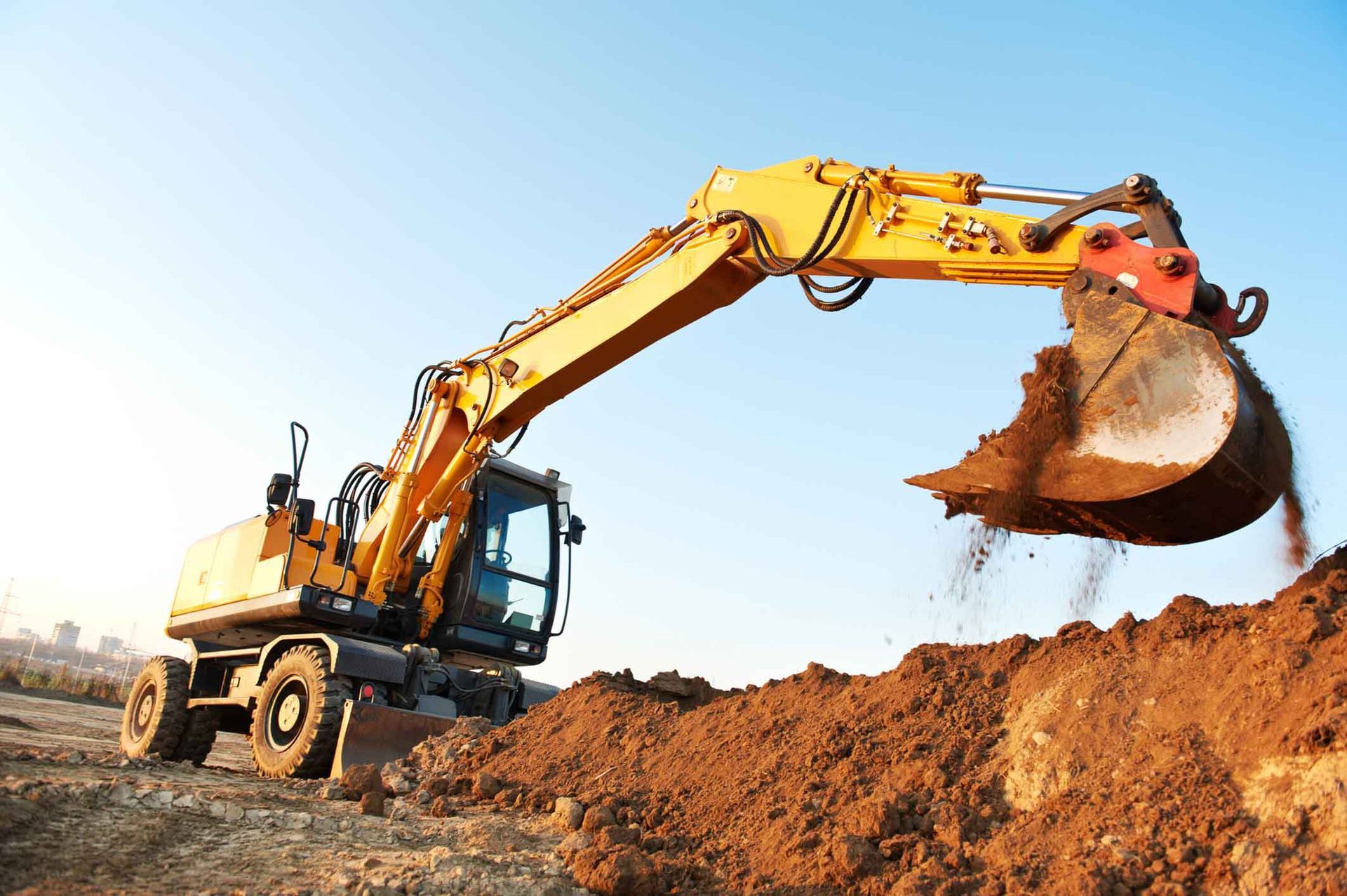 A Yellow Excavator Is Digging A Pile Of Dirt On A Construction Site – Port Pirie, SA - Flinders Earthmoving & Blue Metal Supplies