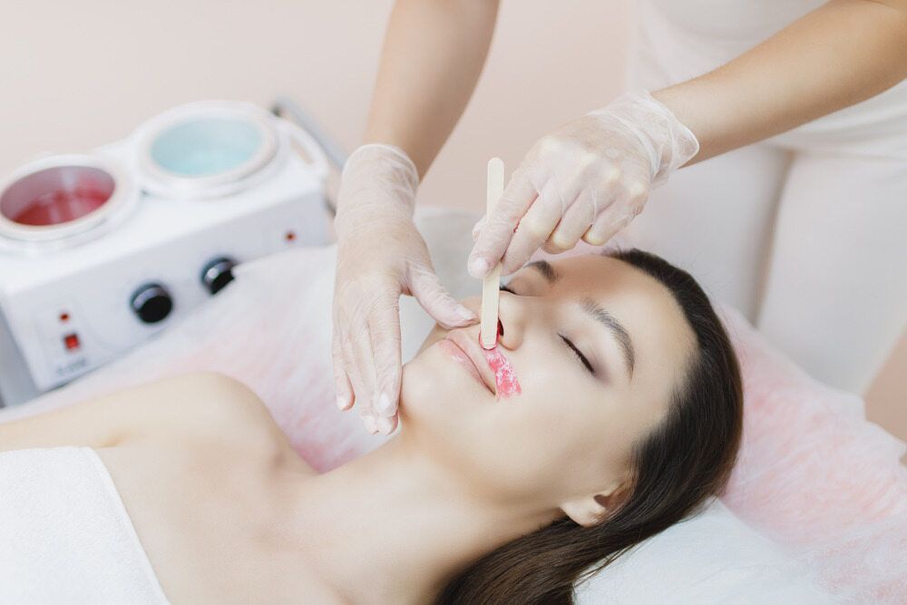 A Woman is Getting Her Lips Waxed in a Beauty Salon — Southside Hair & Beauty Design In South Tamworth, NSW