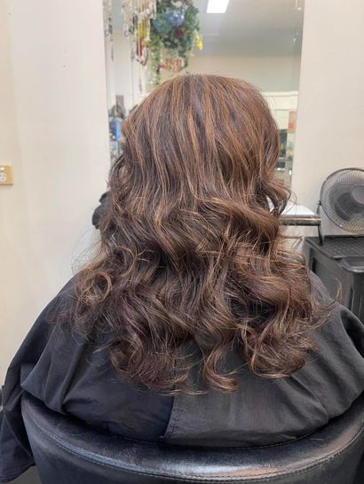 A Woman is Sitting in a Chair With Her Hair in a Salon — Southside Hair & Beauty Design In South Tamworth, NSW
