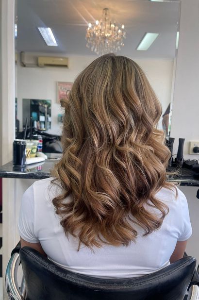A Woman is Sitting in a Chair With Her Hair in a Salon — Southside Hair & Beauty Design In South Tamworth, NSW