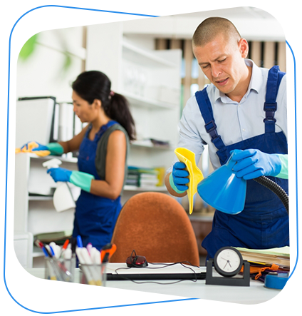 Two people wearing blue cleaning uniforms cleaning an office.
