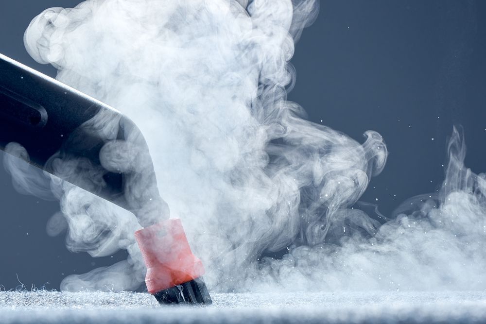 Steam cleaner dispensing vapor onto a surface.