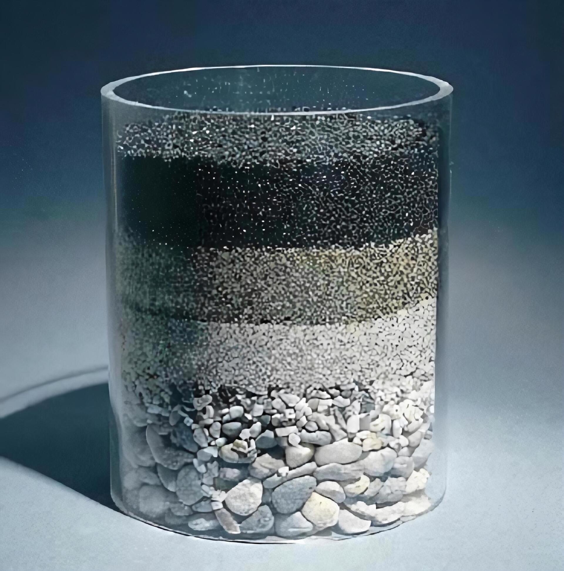 Un cilindro transparente lleno de diferentes tipos de rocas.