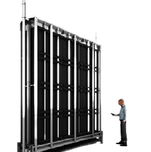 Un hombre está parado frente a una gran pared negra.