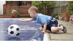 Un niño pequeño está jugando con un balón de fútbol en una piscina.