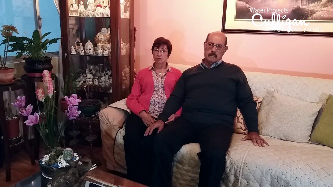 Un hombre y una mujer están sentados en un sofá en una sala de estar.