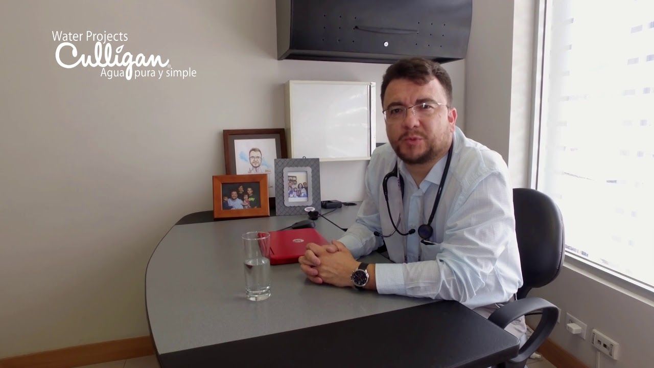 Un hombre está sentado en un escritorio con un estetoscopio alrededor de su cuello.