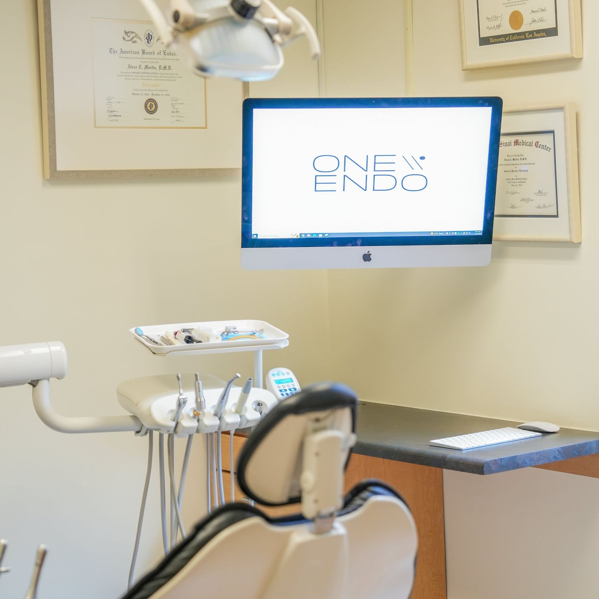 Dental office with an examination chair, equipment, and a computer screen displaying