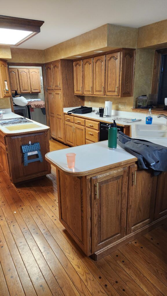 A kitchen with wooden cabinets , a sink , and a stove.