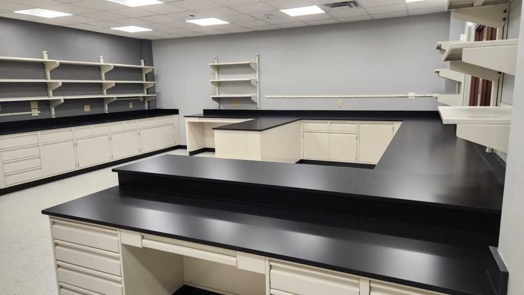 An empty lab with black counter tops and white cabinets