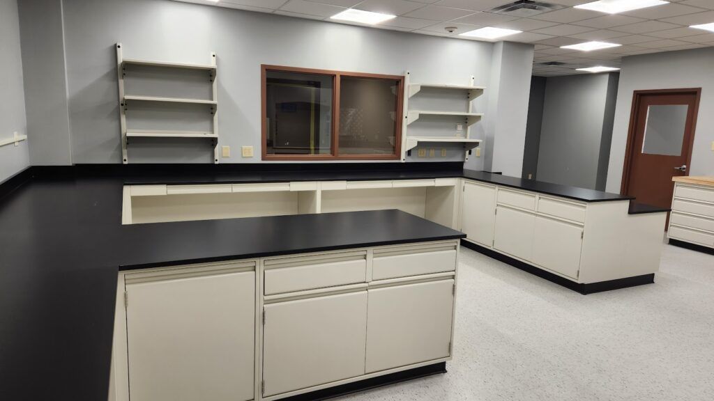 An empty lab with black counter tops and white cabinets