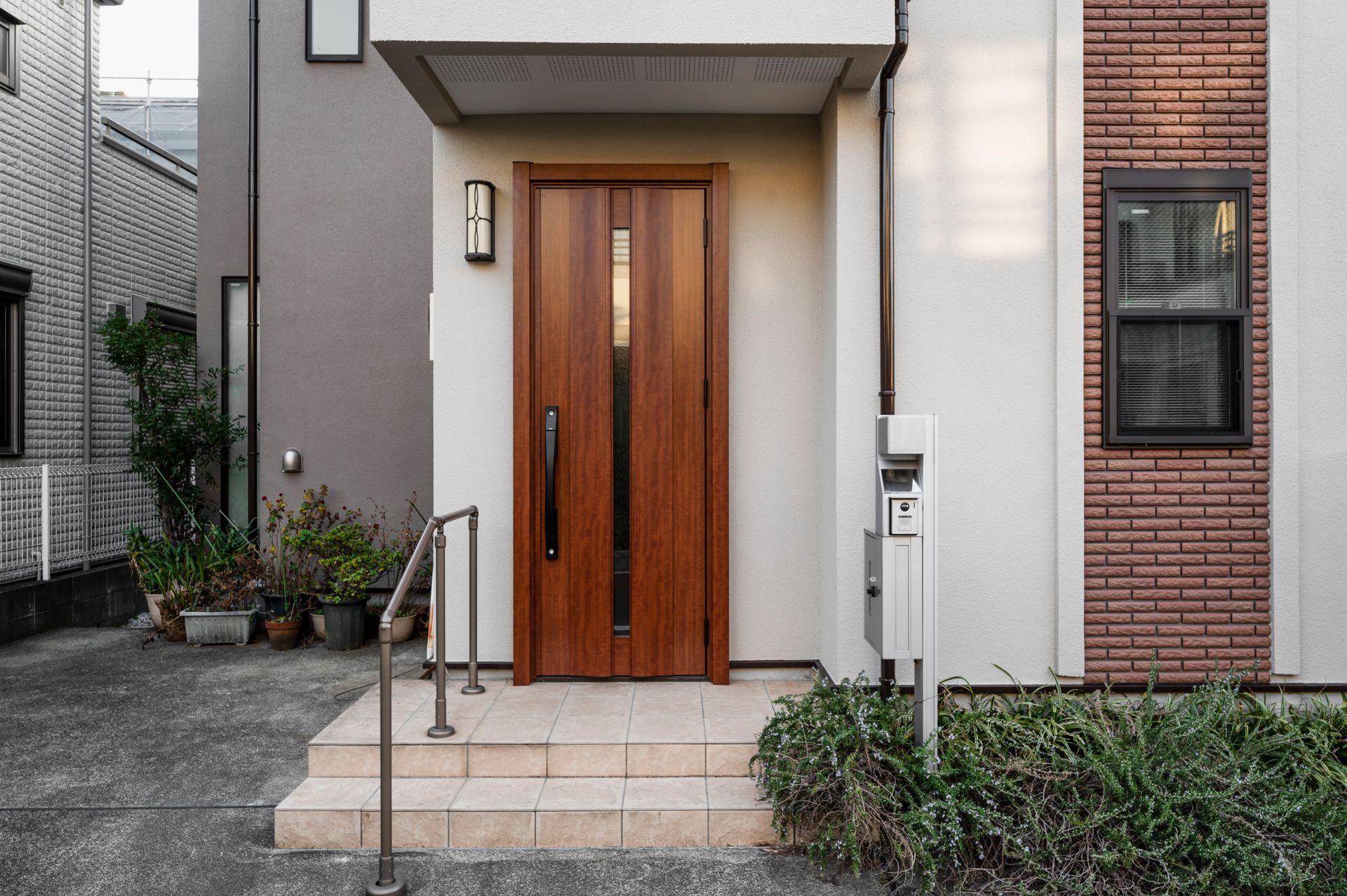 the front door of a house with a wooden door and steps .