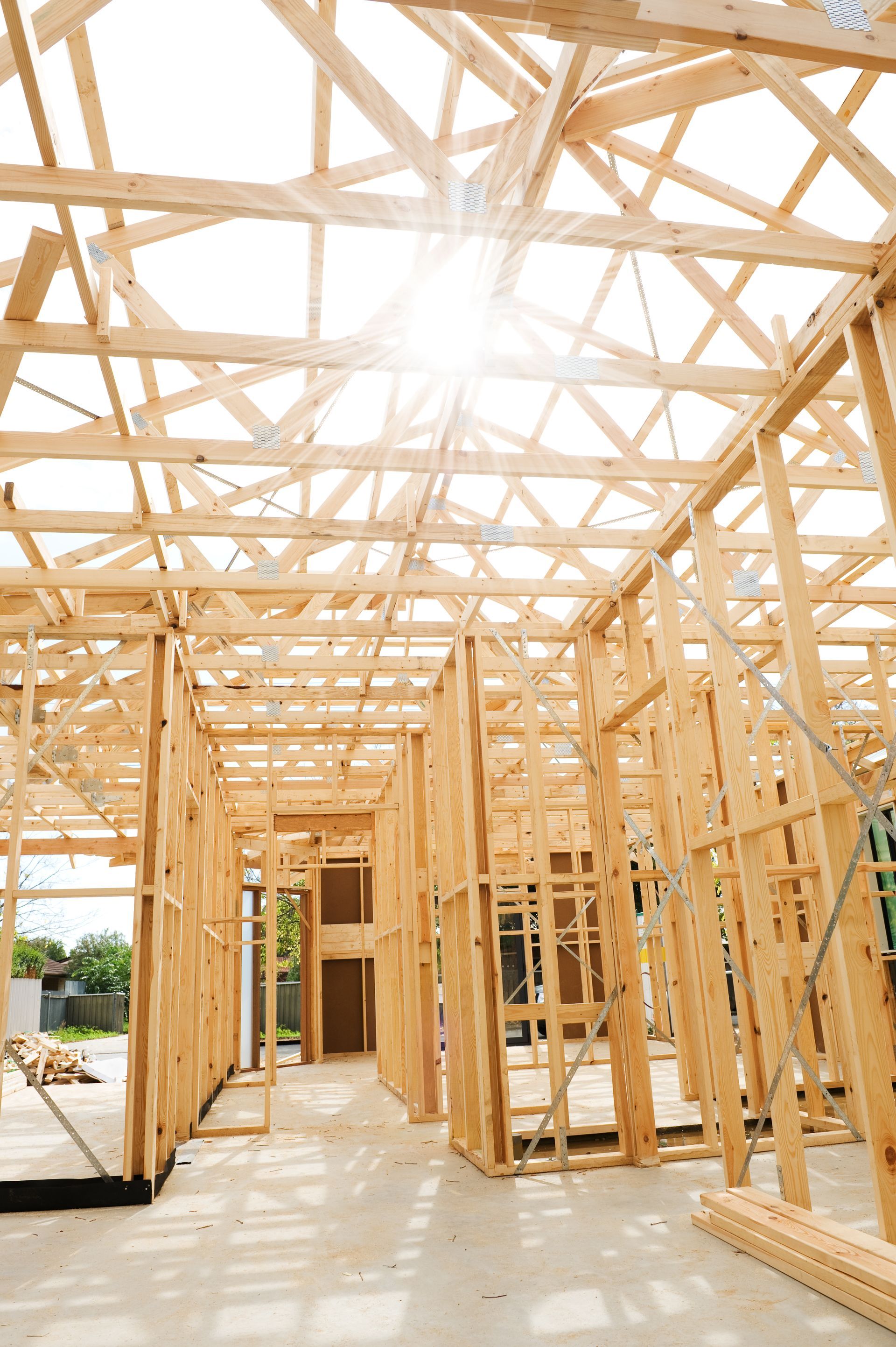 the sun is shining through the roof of a wooden house under construction .