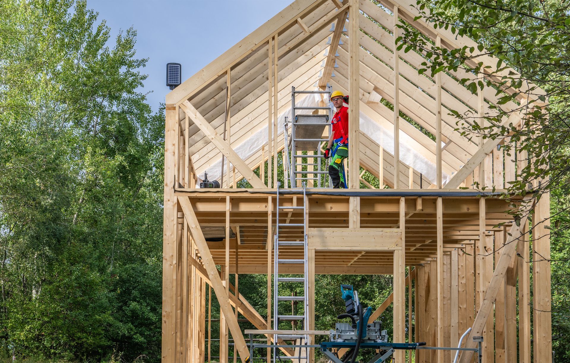 a man is standing on top of a wooden structure under construction .