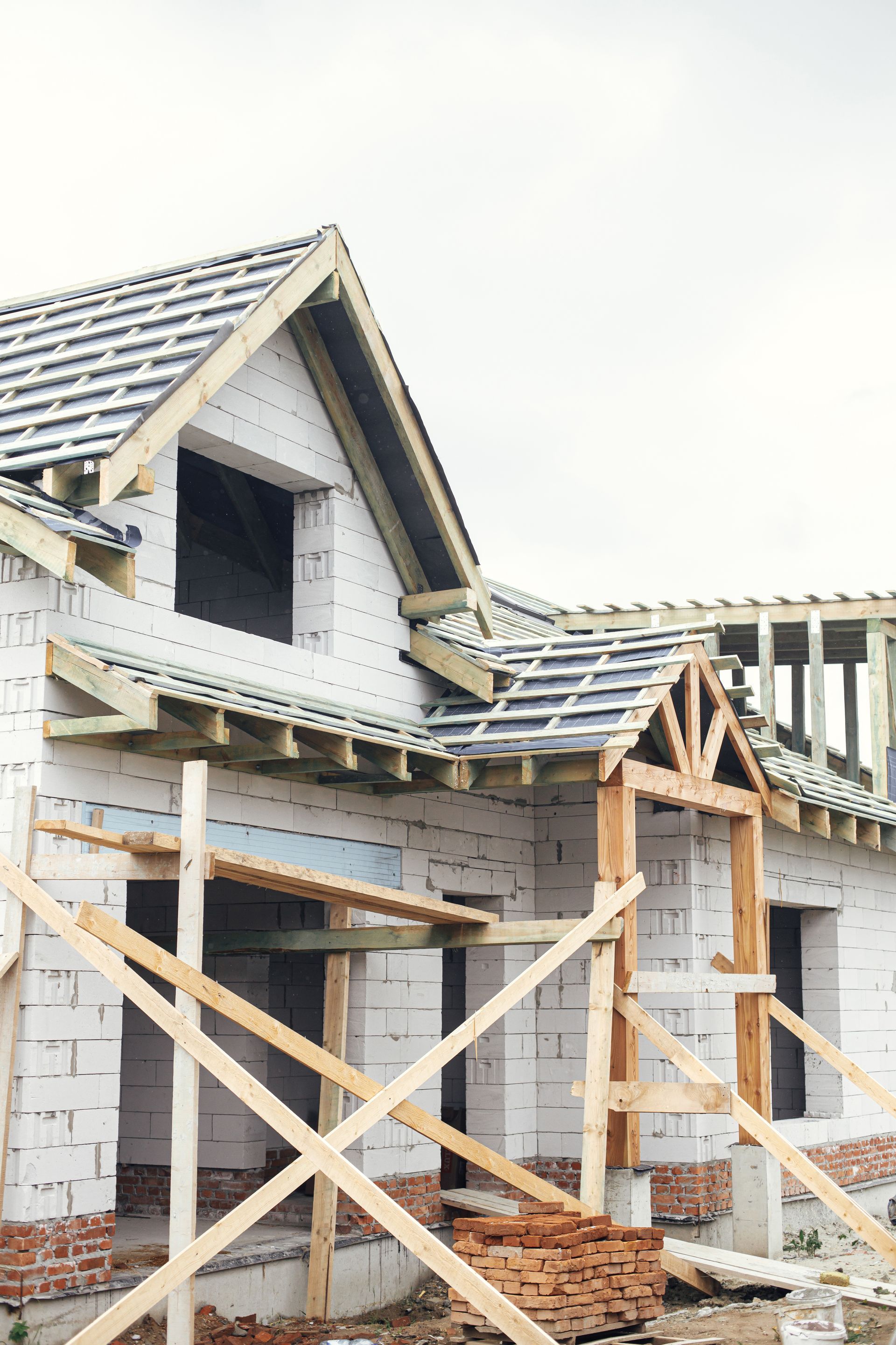 a house is being built with wooden scaffolding around it .