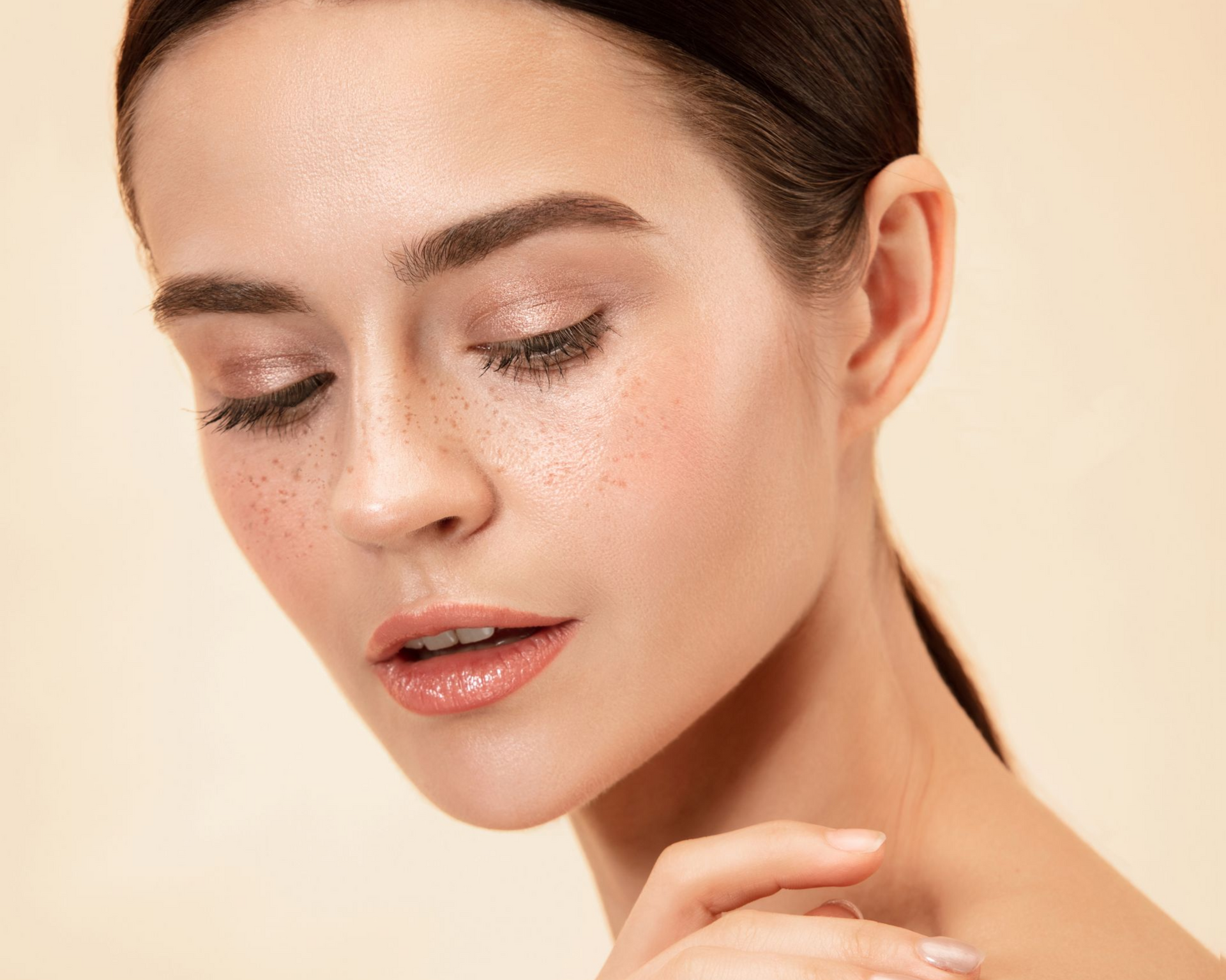 Woman with green eyes and freckles gazes at the camera.