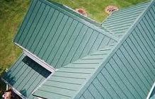 Green metal roof on a house, angled view.