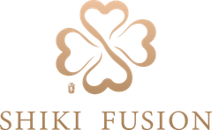 A light gold four-leaf clover logo with an intricate design, positioned above the text "SHIKI FUSION" in a matching font.