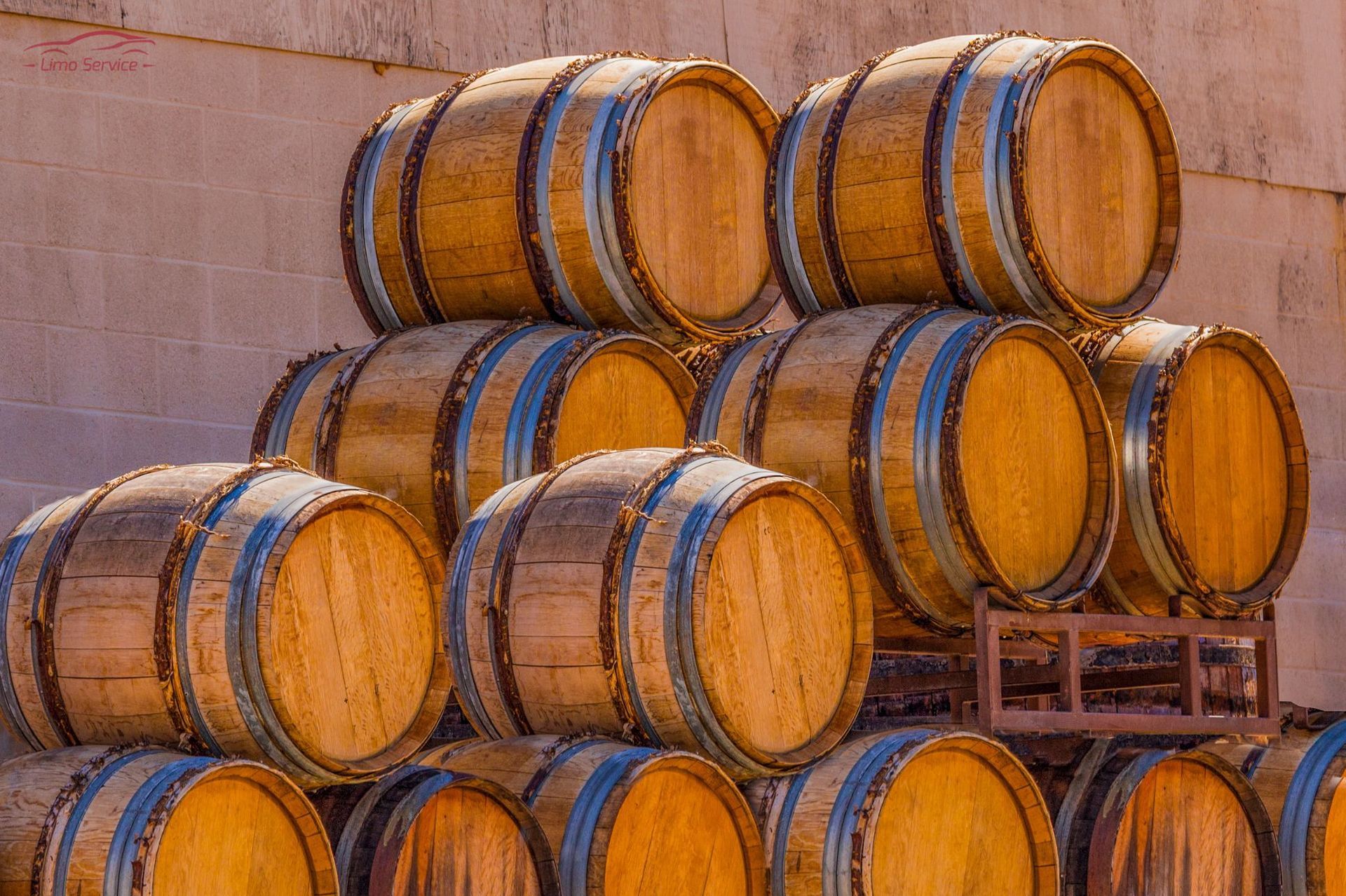 A bunch of wooden barrels are stacked on top of each other.