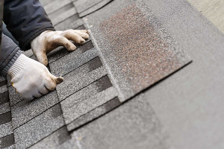 Workman install tile on roof of new house under construction
