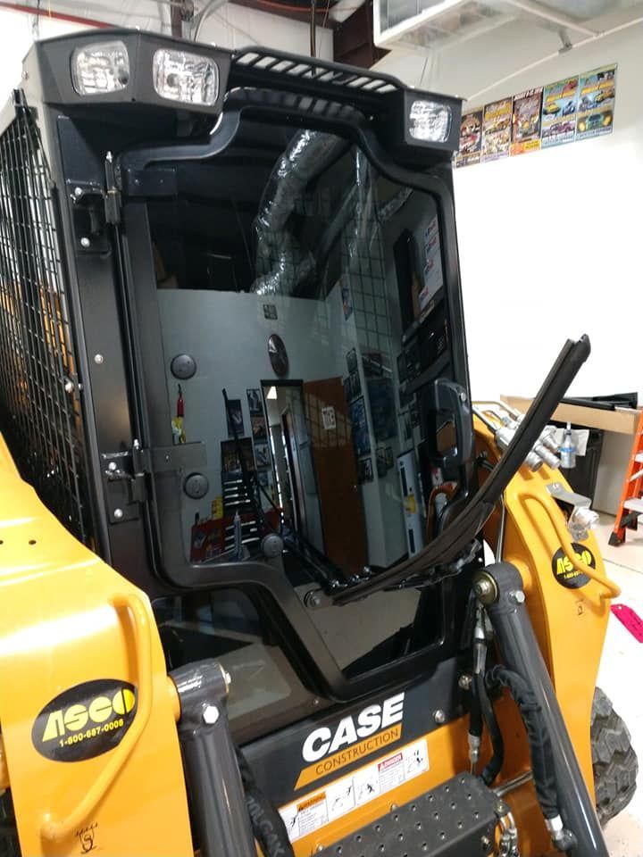 Yellow and black Case skid steer with cab.
