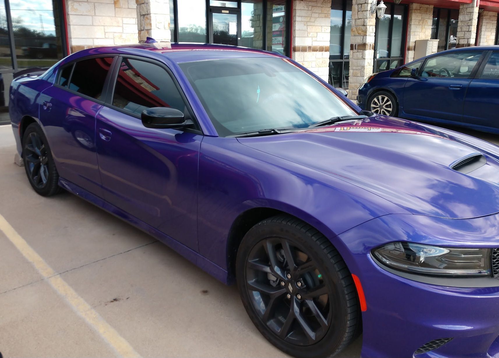 Black Hyundai Santa Cruz pickup truck parked outside a building with red trim.
