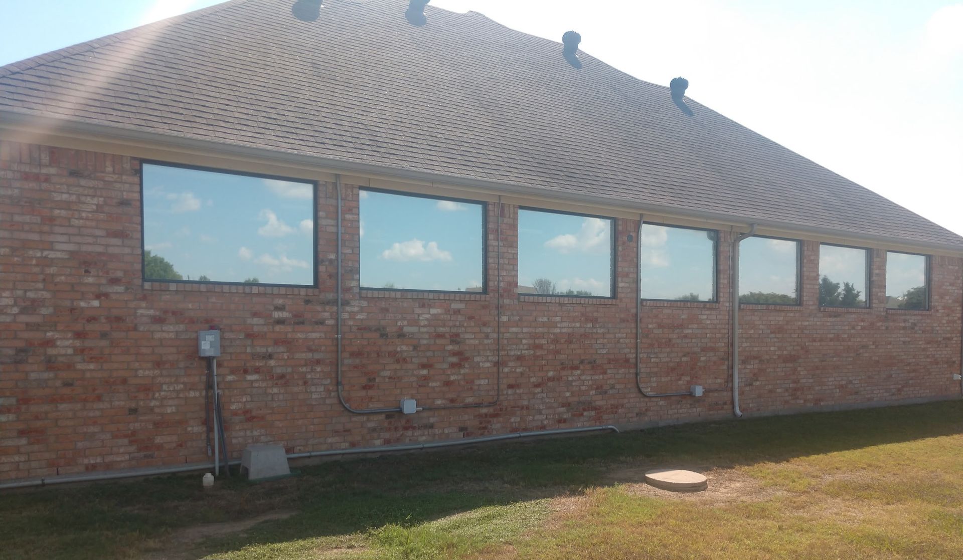 Black Hyundai Santa Cruz pickup truck parked outside a building with red trim.
