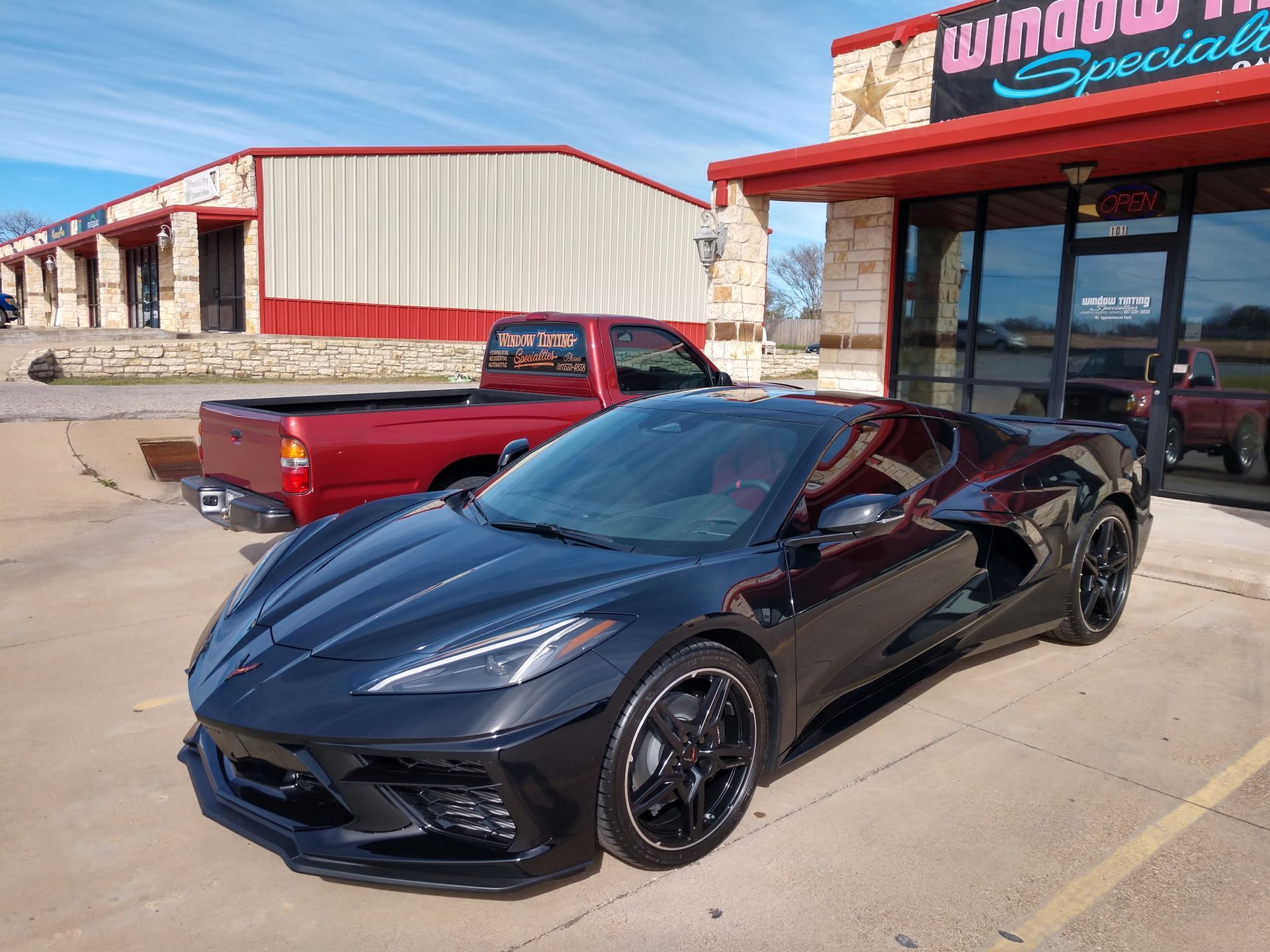 Black Hyundai Santa Cruz pickup truck parked outside a building with red trim.
