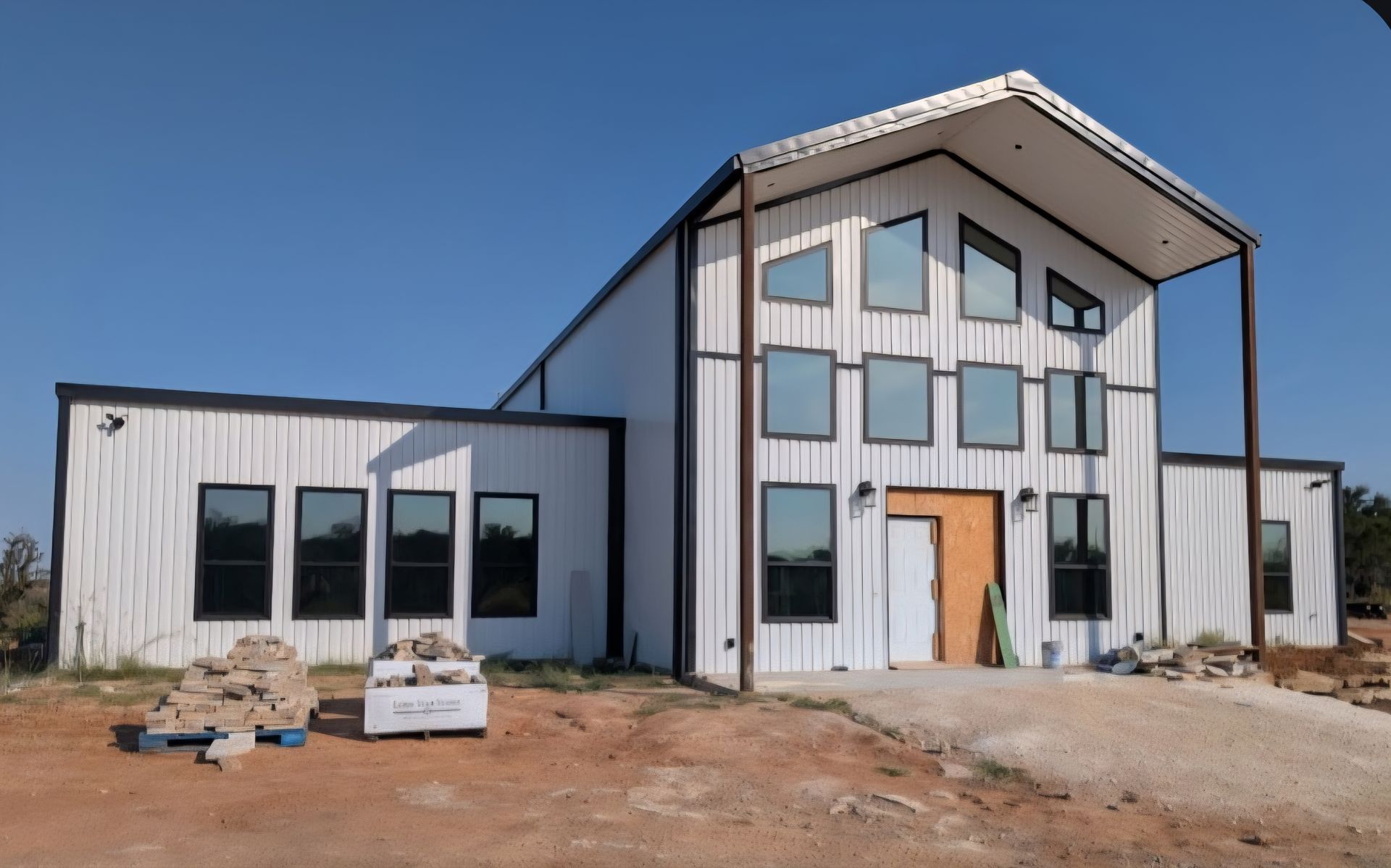 Black Hyundai Santa Cruz pickup truck parked outside a building with red trim.
