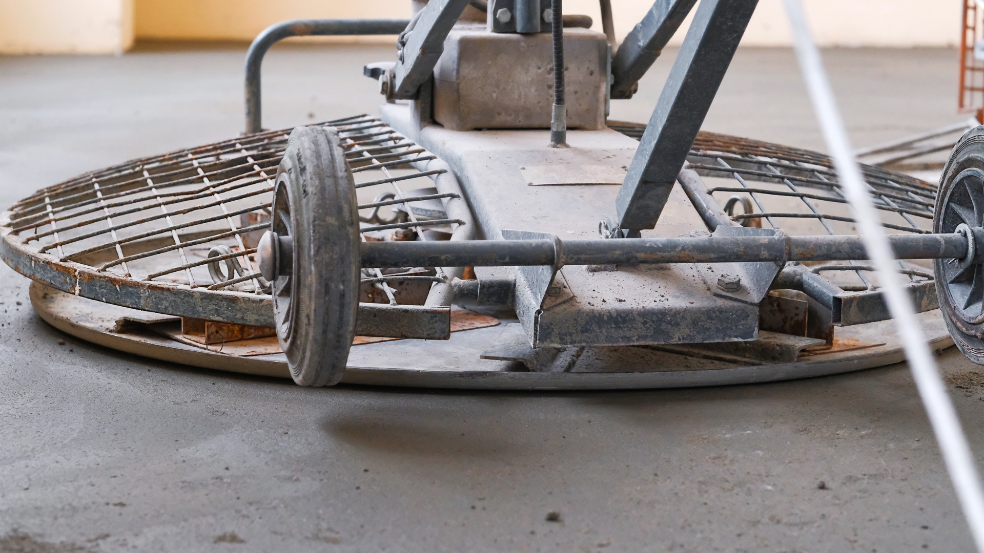 Rusty metal floor-cleaning machine on concrete floor in a workshop setting