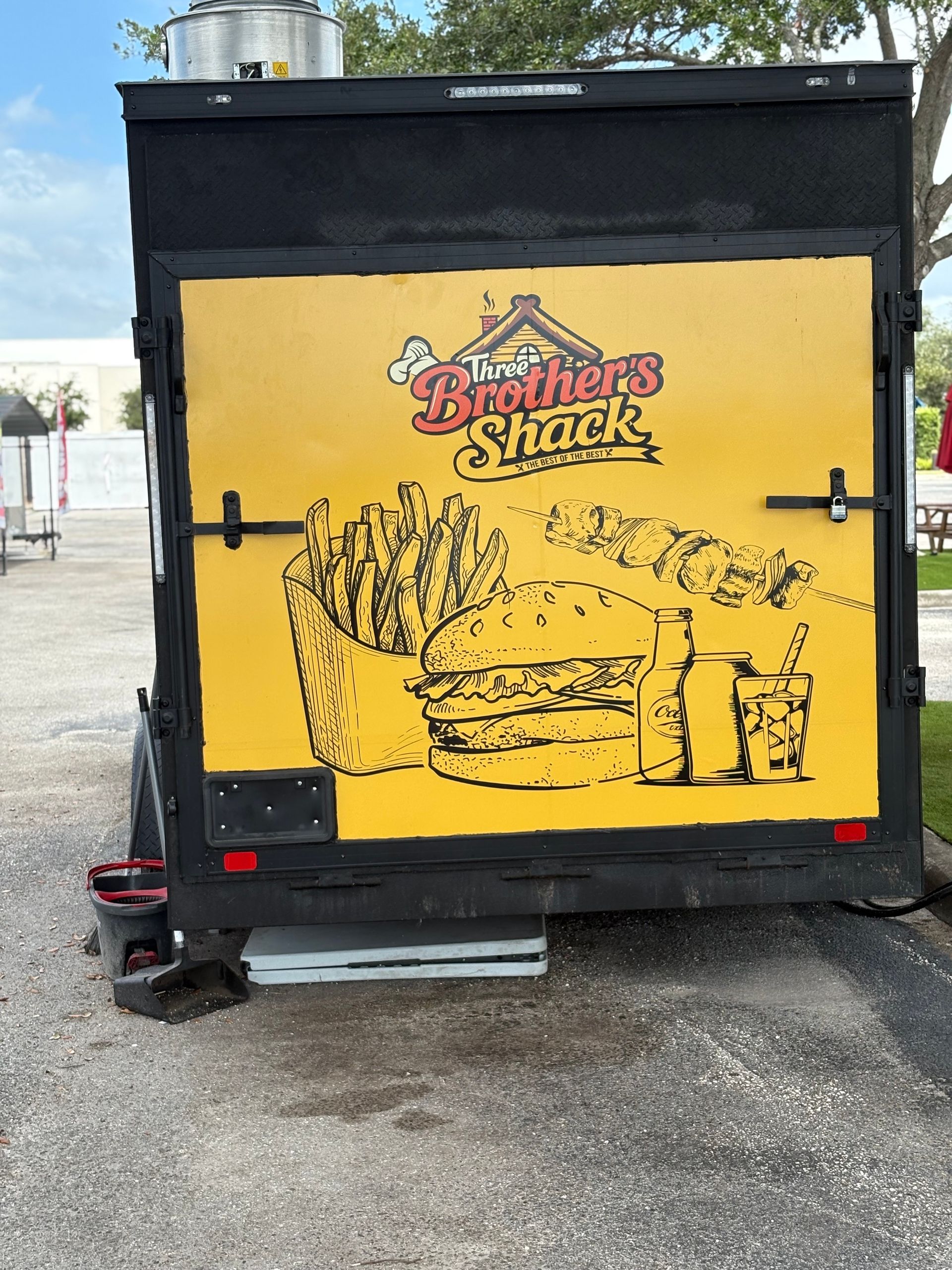 Black food truck with yellow rear panel. 