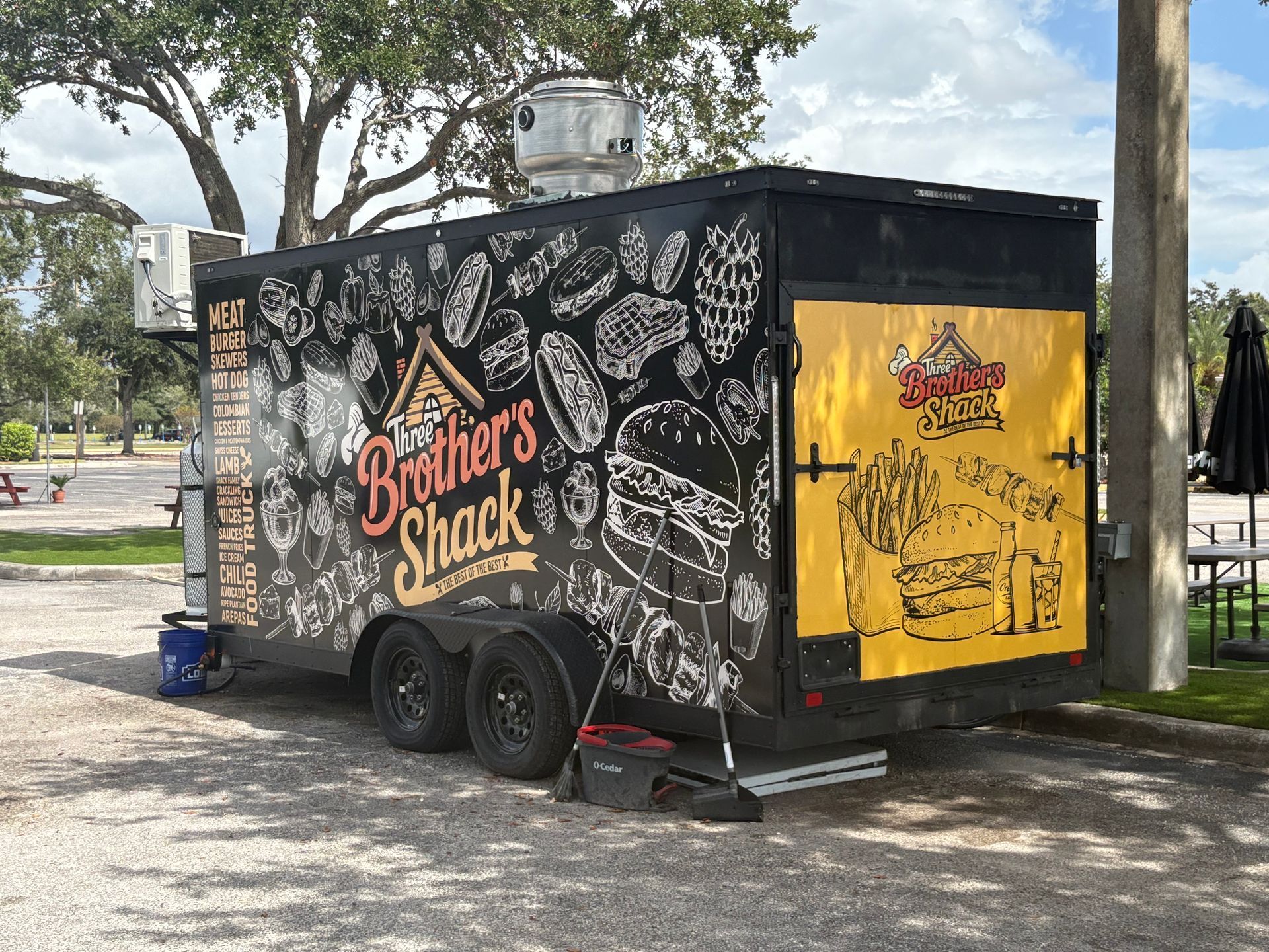 Man operating large-format printer, reviewing a printed graphic on roll of paper in a print shop.
