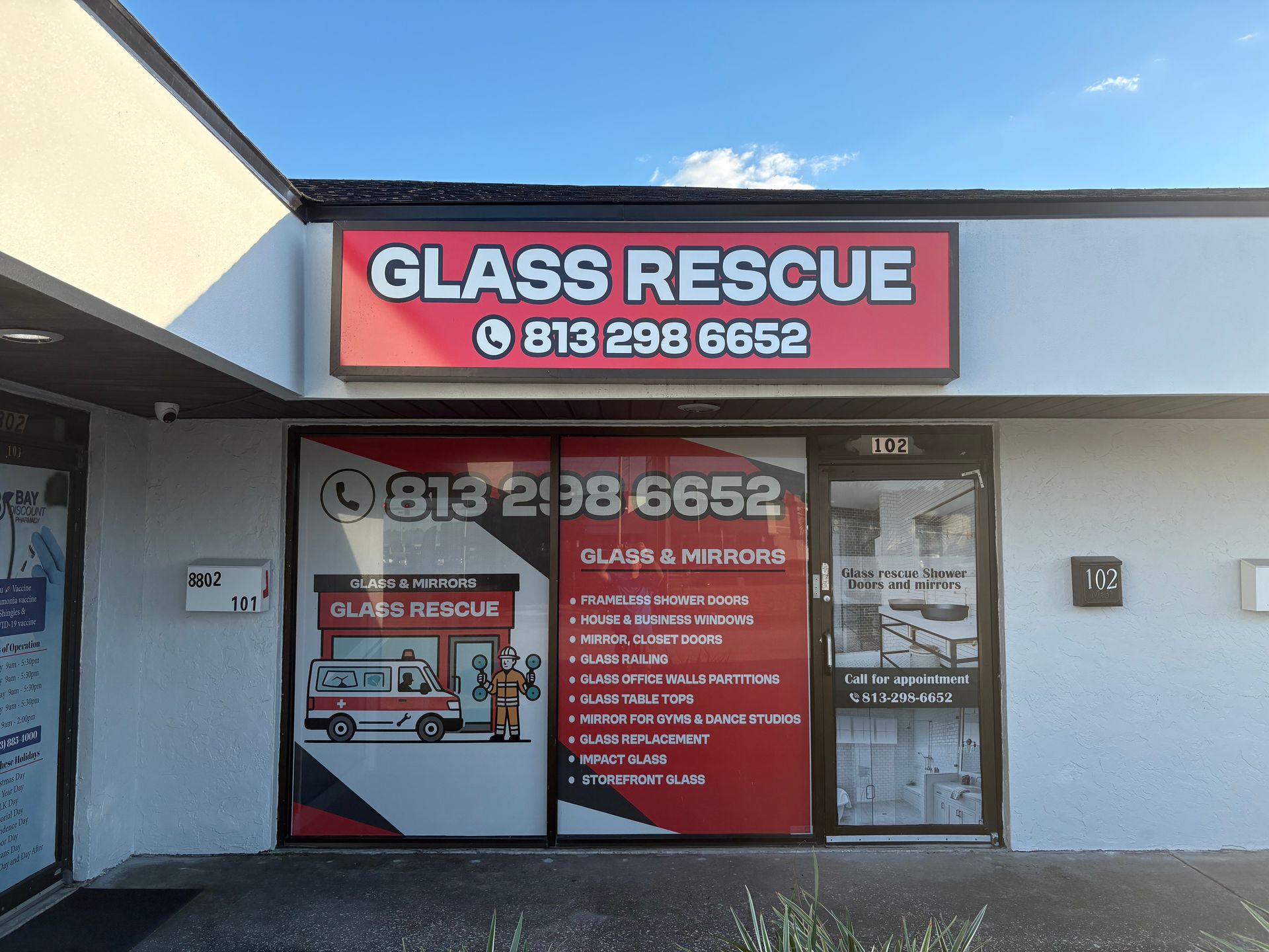 Sign for Glass Rescue business, with phone number, in front of a store.