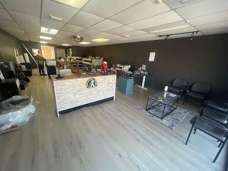 Interior of a commercial space with a front desk, waiting area, and printing equipment.
