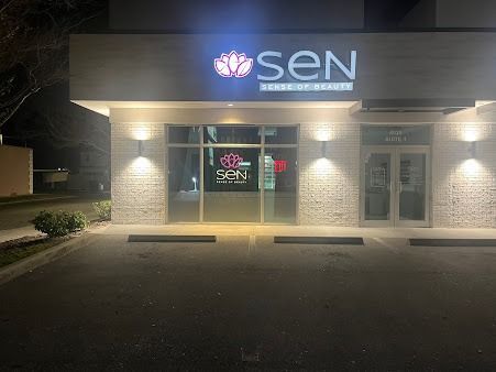 The facade of a beauty salon at night. The sign reads