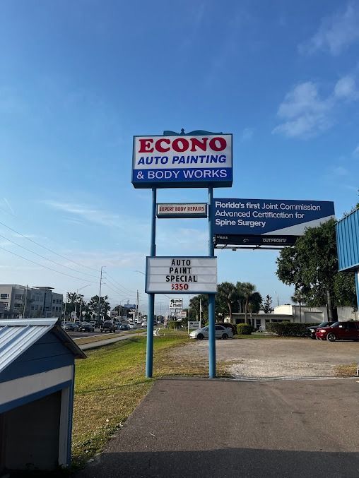 Econo Auto Painting sign on a sunny day. Additional business signs are nearby.