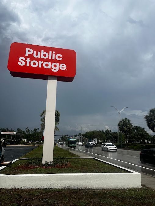 Public Storage sign; red and white; cloudy day, road with cars.