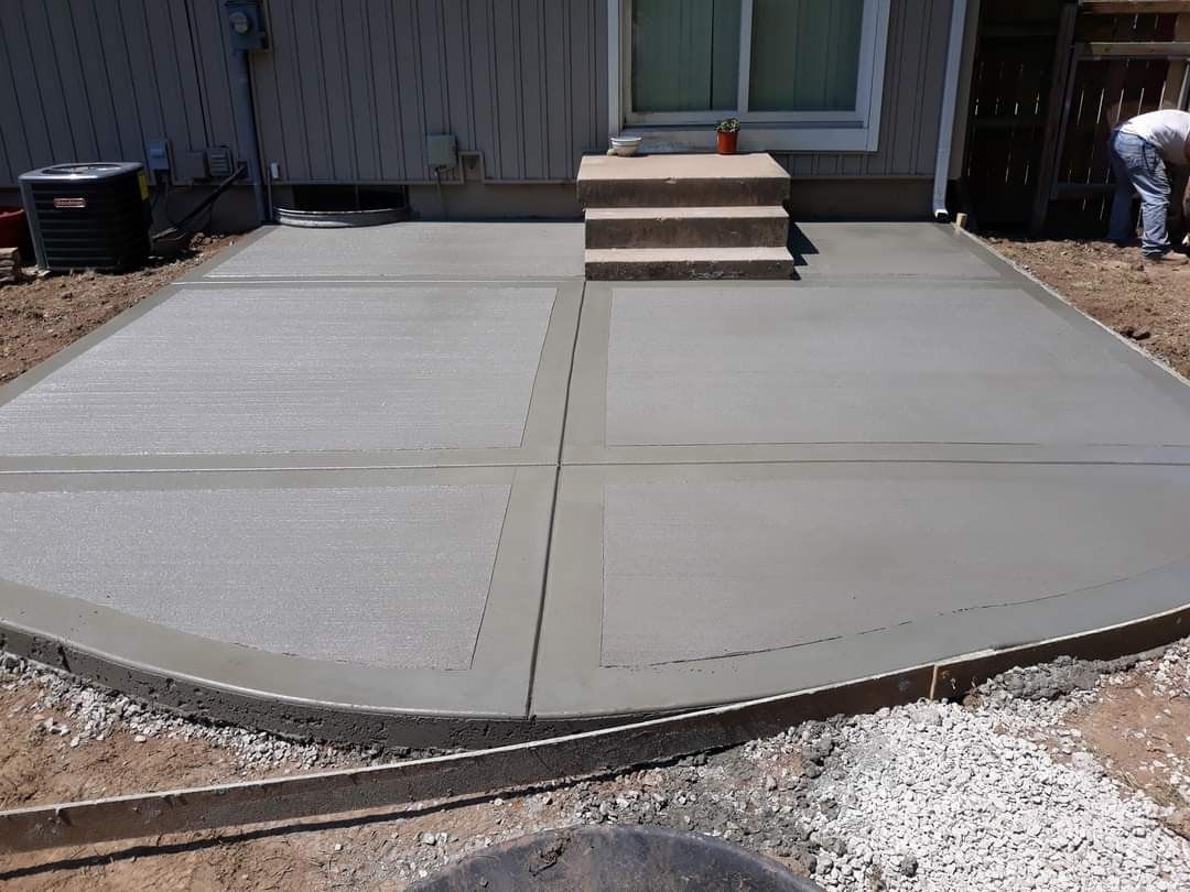 A concrete patio is being built in front of a house.