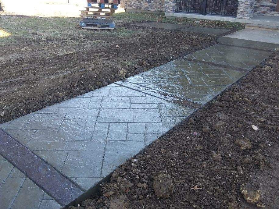 A concrete walkway is being built in front of a house.