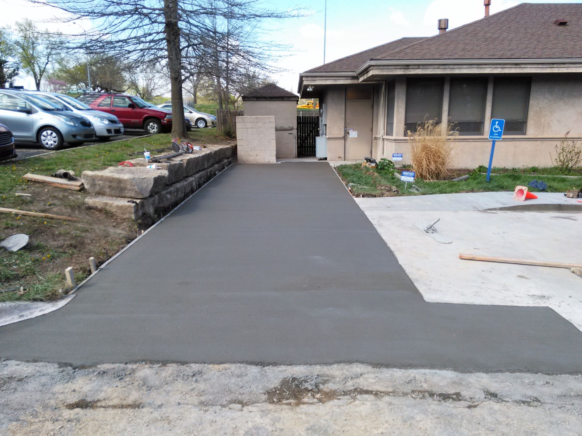 A concrete walkway is being built in front of a house